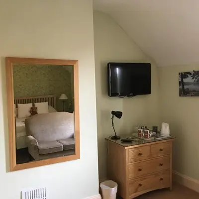 a bedroom with a bed and a mirror and a dresser at Burnside B&B in Keswick