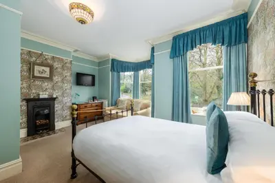 a bedroom with a bed and a fireplace at Burnside B&B in Keswick