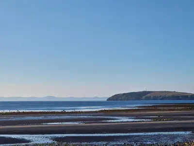 a beach with the ocean and mountains in the background at Number34 in Drummore