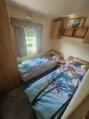 two beds in a small room with a window at Number34 in Drummore