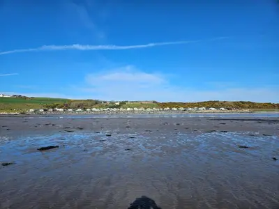 a person standing on a beach with a body of water at Number34 in Drummore