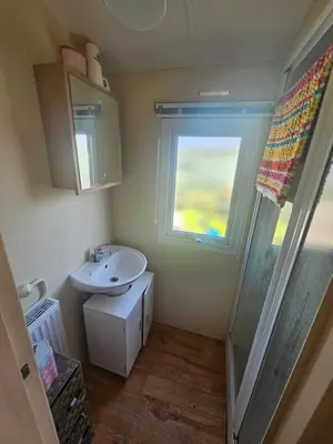 a small bathroom with a sink and a window at Number34 in Drummore