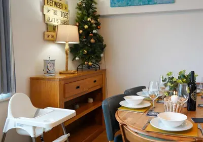 a dining room with a table with a christmas tree at Coppet Cove - 2 Bedroom Apartment - Saundersfoot in Moffat