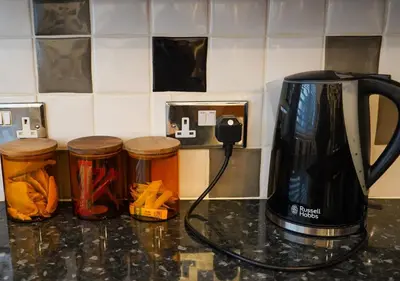 a coffeemaker on a counter with jars and a coffee pot at Coppet Cove - 2 Bedroom Apartment - Saundersfoot in Moffat