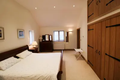 a bedroom with a bed and a wooden door at Mindrum, Skelton a spacious and characterful house close to Penrith & Ullswater in Skelton