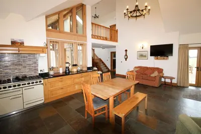 a kitchen with a table and a stove and a couch at Mindrum, Skelton a spacious and characterful house close to Penrith & Ullswater in Skelton