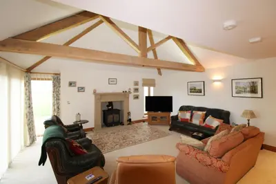 a living room with couches and a tv and a fireplace at Mindrum, Skelton a spacious and characterful house close to Penrith & Ullswater in Skelton