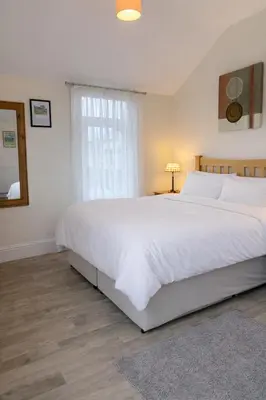 a bedroom with a large white bed and a window at The Manor House in Peel