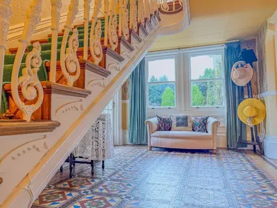 a living room with a staircase and a couch at Eden Mount, Wetheral, characteful, spacious home overlooking village green, close to M6 in Wetheral