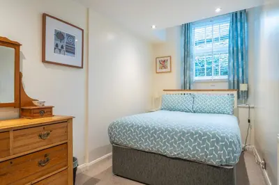 a bedroom with a bed and a dresser and a window at Ben Place Cottage - Grasmere in Grasmere