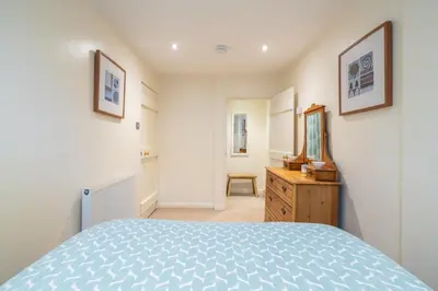 a bedroom with a bed and a dresser and a mirror at Ben Place Cottage - Grasmere in Grasmere
