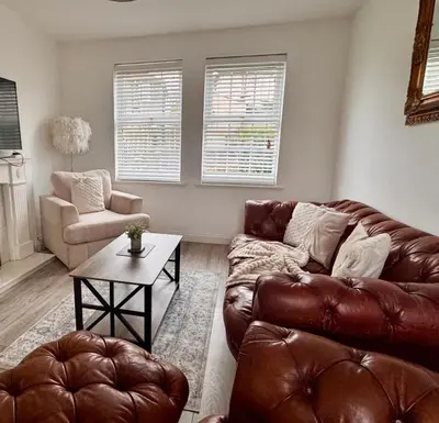 a living room with a leather couch and a table at Modern 3 Bedroom Home in Egremont, Western Lake District, Sleeps up to 6 in Egremont