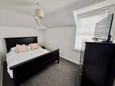 a bedroom with a black bed and a window at Modern 3 Bedroom Home in Egremont, Western Lake District, Sleeps up to 6 in Egremont