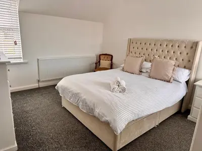 a bedroom with a large bed with two stuffed animals on it at Modern 3 Bedroom Home in Egremont, Western Lake District, Sleeps up to 6 in Egremont