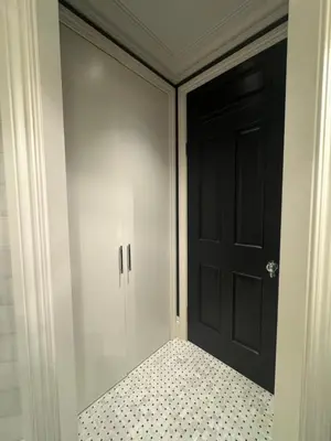 a bedroom with a black door and a tiled floor at West London Boutique Apartment in Moffat