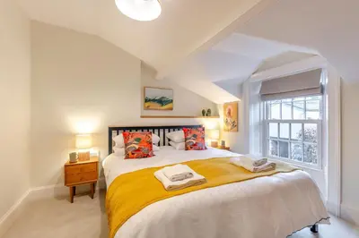 a bedroom with a large bed with yellow sheets and a window at 5 Bed in Keswick oc-h33619 in Keswick