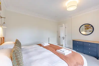 a bedroom with a large bed and a mirror at 5 Bed in Keswick oc-h33619 in Keswick