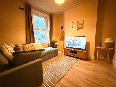 a living room with a couch and a flat screen tv at Contractor 4BD Carlisle Long Stay w Wi-Fi, Washer, Smart TVs & Parking in Carlisle