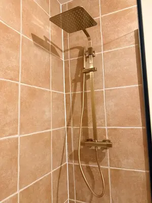 a shower with a shower head in a bathroom at Contractor 4BD Carlisle Long Stay w Wi-Fi, Washer, Smart TVs & Parking in Carlisle