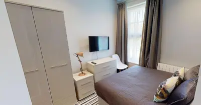 a bedroom with a bed and a dresser and a tv at Modern En-suite Room in Moffat