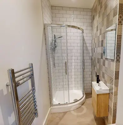 a bathroom with a shower and a toilet and a sink at Modern En-suite Room in Moffat