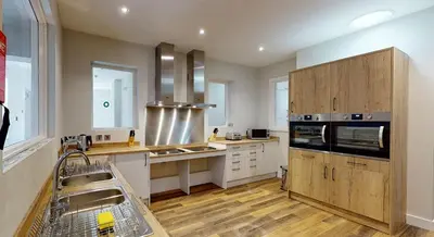 a large kitchen with a sink and a dishwasher at Modern En-suite Room in Moffat