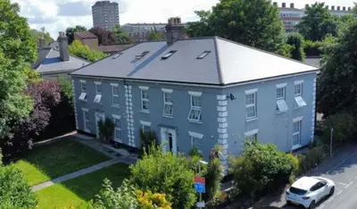 a blue house with a car parked in front of it at Modern En-suite Room in Moffat