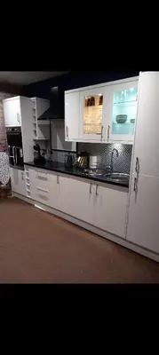 a large kitchen with white cabinets and appliances at Town Centre Apartment in Gatehouse of Fleet