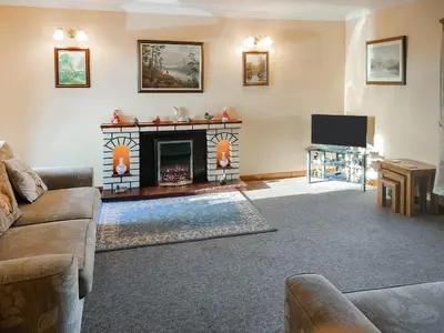 a living room with a couch and a fireplace at East Challoch Farm Dairy Cottage in Stranraer