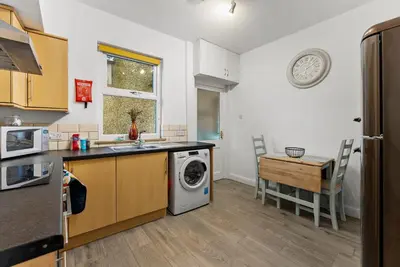 a kitchen with a washing machine and a table at Vintage 2 Bed House in Lamplugh in Lamplugh