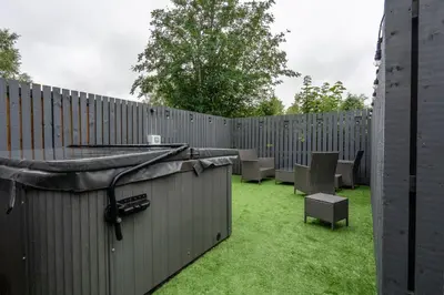 a backyard with a fence with chairs and a hot tub at Moffat Apartment with Hot Tub in Moffat