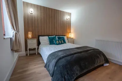a bedroom with a bed with blue pillows on it at Moffat Apartment with Hot Tub in Moffat