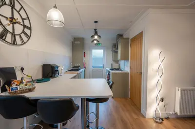 a kitchen with a table and chairs and a clock on the wall at Moffat Apartment with Hot Tub in Moffat