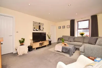 a living room with a couch and a flat screen tv at Peaceful Village Flat 2 Bedrooms in Douglas
