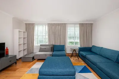 a living room with blue couches and a couch at Knightsbridge Duplex Two Bedroom Apartment in Moffat