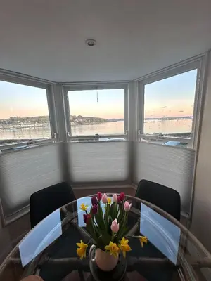 a dining room with a glass table with flowers on it at THE WHEEL,Harbour view apartment for two - private front entrance and patio in Moffat