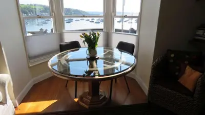 a glass table with a vase of flowers on it in a room at THE WHEEL,Harbour view apartment for two - private front entrance and patio in Moffat