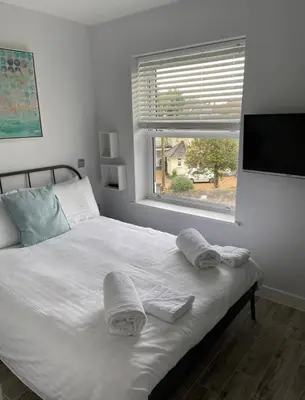 a bedroom with a white bed with towels on it at The Palms in Moffat