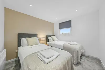 a bedroom with two beds and a window at The Penthouse - Beachwalk Apartments in Ayr