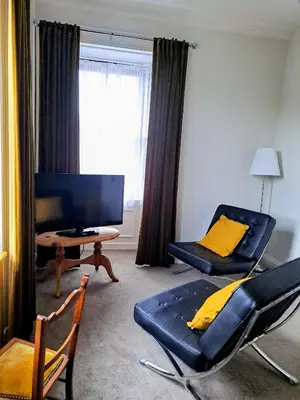 a living room with a couch and a chair and a desk at Brewery house in Newton Stewart