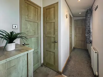 a hallway with two wooden doors and a plant at Millars Caravan in Ayr