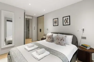 a bedroom with a large bed with two towels on it at Stylish 2-Bedroom Flat On Seven Sisters Rd in Moffat