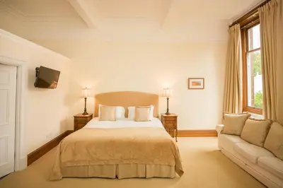 a bedroom with a large bed and a couch at Springkell in Eaglesfield
