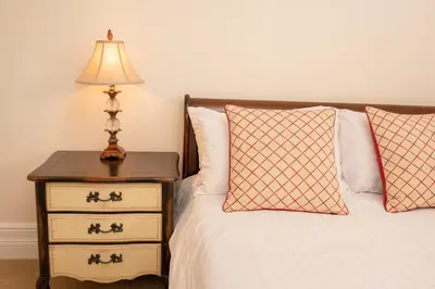 a bed with a nightstand with a lamp and two pillows at Springkell in Eaglesfield