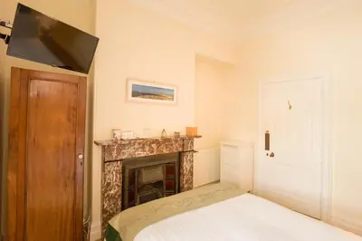 a bedroom with a fireplace and a flat screen tv at Springkell in Eaglesfield