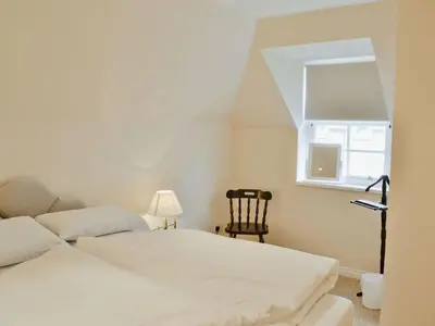 a bedroom with two beds and a chair and a window at Holiday Home Gehöft 2 by Interhome in Tweedsmuir