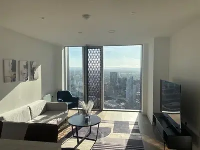 a living room with a couch and a table in front of a window at Skyline view 2 bedroom apartment in Moffat