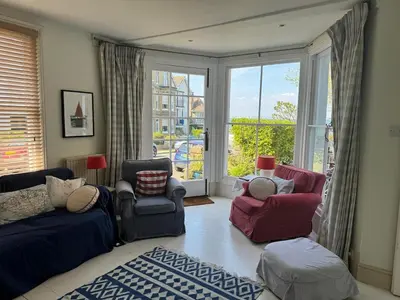 a living room with a couch and chairs and a window at Regents House, ground floor apartment with sea views in Moffat