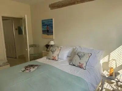 a white bed with pillows and a towel on it at Regents House, ground floor apartment with sea views in Moffat