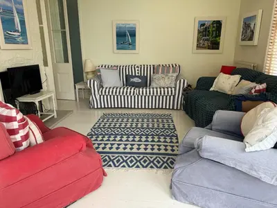 a living room with several couches and a tv at Regents House, ground floor apartment with sea views in Moffat